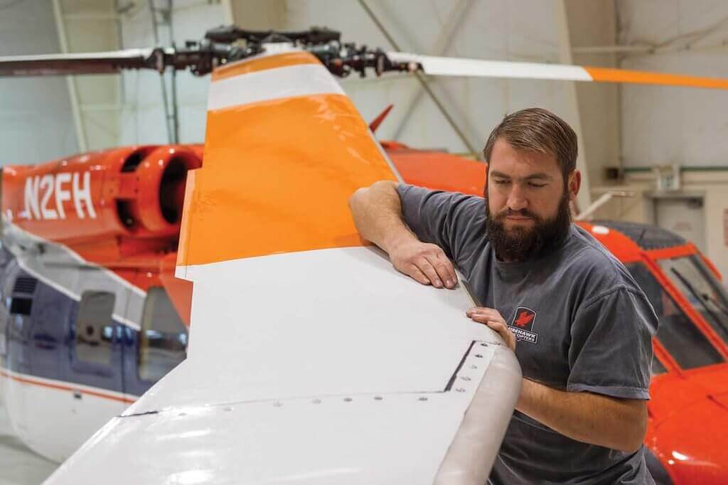 Maintenance technician Levi Davis inspects and cleans main rotors after a busy fire season at the Boise, Idaho, base.